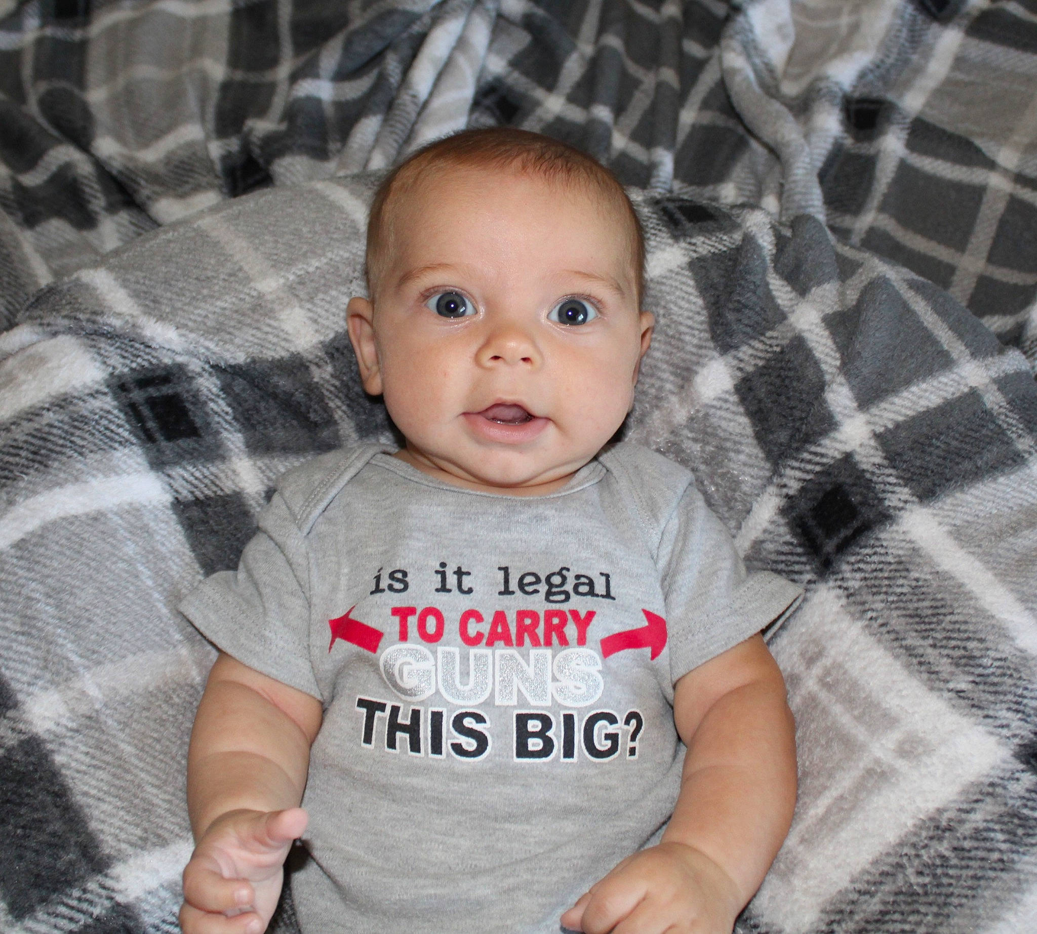 Brodie is registered to the contest to win money with this photo: baby, baby_toddler_clothing, cheek, comfort, cool, eye, grey, happy, iris, linens, pattern, person, plaid, product, skin, sleeve, smile, t_shirt, tartan, textile