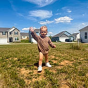 Rhett-Michael joined the competition — help win amazing prizes! toddler, child, grass, field, suburban, houses, blue_sky, clouds, smiling, waving, outdoor, sunny, casual_clothing, young_child, walking, daylight, residential_area, happy, bare_legs, shoes