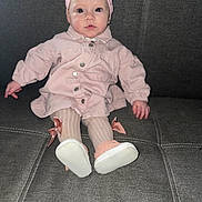 Rosalia participe au concours pour gagner de l'argent avec cette photo : baby, infant, child, pink_clothing, hat, jacket, tights, bow, shoes, feet, face, eyes, sitting, couch, sofa, buttons, indoor, portrait, curious_expression, soft_fabric
