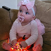 Bailey joined the competition — help win amazing prizes! baby, child, pacifier, headband, bow, pink_clothing, pumpkin, string_lights, glowing_lights, couch, indoors, cute, blue_eyes, toddler, sitting, barefoot, decor, holiday, soft_lighting, curious