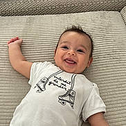 Aaron participe au concours pour gagner de l'argent avec cette photo : baby, smiling, onesie, roller_skates, text_on_clothing, lying_down, arm, happy, infant, child, indoor, soft_surface, fabric_texture, person, cute, portrait, closeup, skin, casual, relaxing