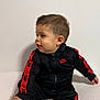 Mattéo participe au concours pour gagner de l'argent avec cette photo : toddler, child, nike, tracksuit, black_clothing, red_stripes, sitting, white_background, cushioned_surface, curious_expression, indoor, young_child, portrait, casual_clothing, baby, short_hair, socks, fashion, person, side_profile