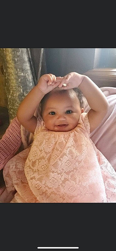 Aaliyah is registered to the contest to win money with this photo: arm, baby, baby_toddler_clothing, chin, dress, eyebrow, eyelash, facial_expression, finger, flash_photography, gesture, hand, happy, iris, lip, neck, nose, person, skin, sleeve