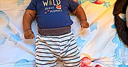 Idris joined the competition — help win amazing prizes! baby, bedroom, black_socks, blanket, blue_shirt, child, colorful, crib, happy, hat, indoor, infant, lying_down, nursery, photography, portrait, smiling, star_pattern, striped_clothing, teddy_bear
