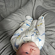 Martin is registered to the contest to win money with this photo: baby, infant, onesie, blanket, soft, sleepwear, cute, lying_down, indoors, child, newborn, face, head, skin, blue_eyes, plush, comfort, resting, peaceful, warm