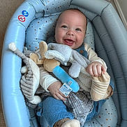 Oscar is registered to the contest to win money with this photo: baby, blanket, blue, child, clothing, comfort, cozy, cute, happy, indoor, infant, person, plush_toy, resting, seat, smile, socks, soft, toy, young