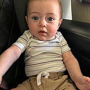 Kayden is registered to the contest to win money with this photo: baby, child, infant, calvin_klein, striped_shirt, beige_shorts, leather_chair, blue_eyes, short_hair, mohawk, cute, sitting, indoor, curious, person, apparel, casual_clothing, closeup, portrait, young
