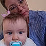 Joy participe au concours pour gagner de l'argent avec cette photo : baby, pacifier, woman, glasses, blue_shirt, pink_bow, face, portrait, closeup, indoor, person, child, infant, head, hair, expressionless, parent, family, casual, skin
