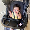 Alena is registered to the contest to win money with this photo: baby, stroller, child, infant, smiling, yellow_outfit, pacifier, baby_trend, outdoor, sunny, happy, seat, footwear, plastic_tray, mesh_backrest, concrete_floor, brick_wall, baby_carriage, baby_walker, person