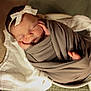 Rowan is registered to the contest to win money with this photo: newborn, baby, sleeping, wrapped, blanket, headband, bow, basket, soft, cozy, peaceful, infant, cute, resting, hands, foot, white_cloth, warm_lighting, portrait, indoors