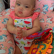 Makayla joined the competition — help win amazing prizes! baby, infant, pink_bows, fruit_pattern, unicorn_cushion, colorful_book, cute, child, lying_down, soft_toy, indoors, clothing, headwear, face, hand, toy, fabric, pattern, comfort, resting