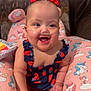 Makayla is registered to the contest to win money with this photo: baby, child, smiling, nasal_cannula, bows, unicorn, patterned_cushion, sitting, happy, infant, cute, indoors, colorful, plush_cushion, cheerful, person, young_child, bright, face, clothing