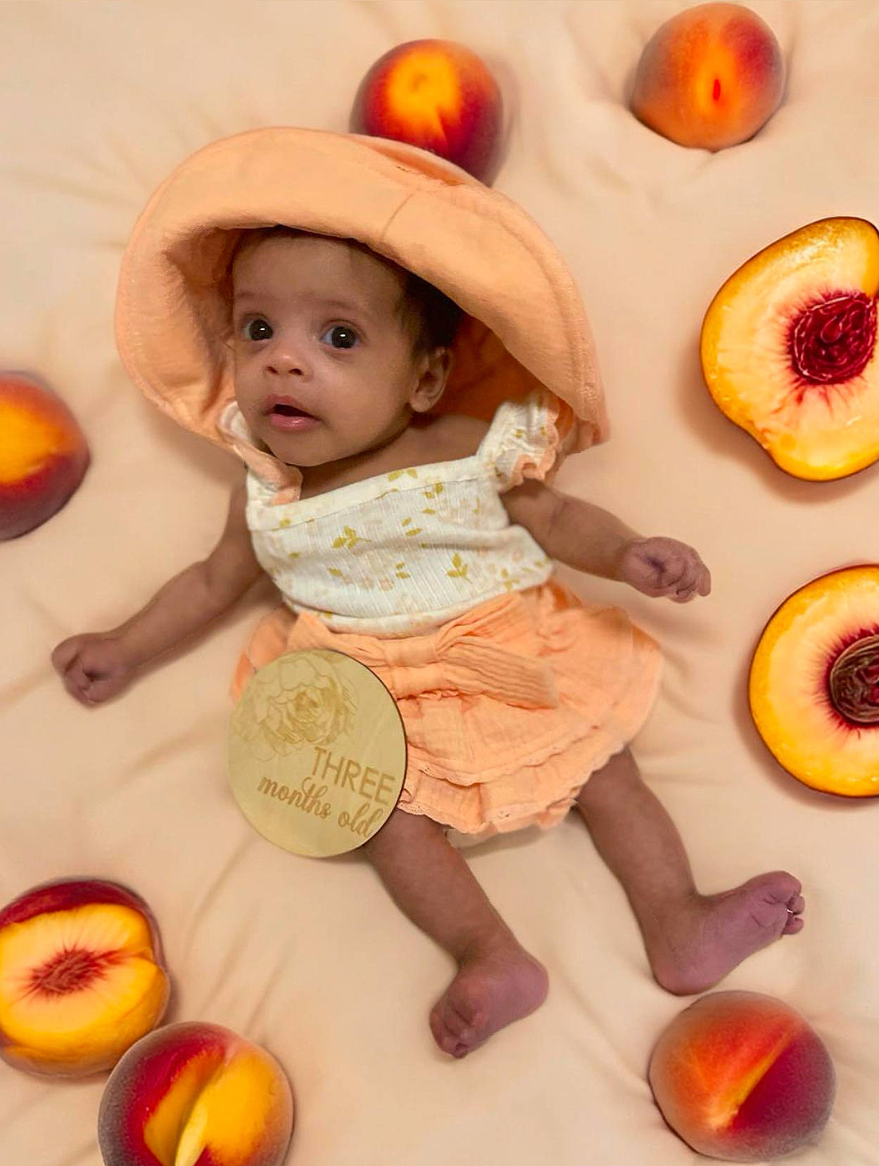 Tala is registered to the contest to win money with this photo: baby, baby_toddler_clothing, calabaza, child, facial_expression, food, fruit, fun, happy, headwear, ingredient, natural_foods, orange, peach, person, produce, pumpkin, sitting, surprise, sweetness