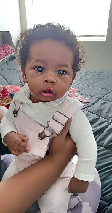 Nakia joined the competition — help win amazing prizes! baby, baby_toddler_clothing, cheek, chest, child, comfort, dress, elbow, eyelash, fun, gesture, happy, linens, lip, mouth, nose, person, sitting, skin, sleeve