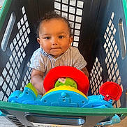 Huxley joined the competition — help win amazing prizes! baby, child, shopping_basket, toy, steering_wheel, indoor, floor, curly_hair, clothing, play, bright_colors, plastic, cute, person, portrait, looking_up, expression, seat, hands, young