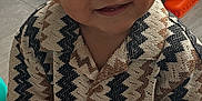 Huxley joined the competition — help win amazing prizes! toddler, child, smiling, curly_hair, indoor, floor, patterned_shirt, beige_shorts, sitting, toy, play, cute, happy, person, young_child, casual_clothing, sock, home, portrait, baby