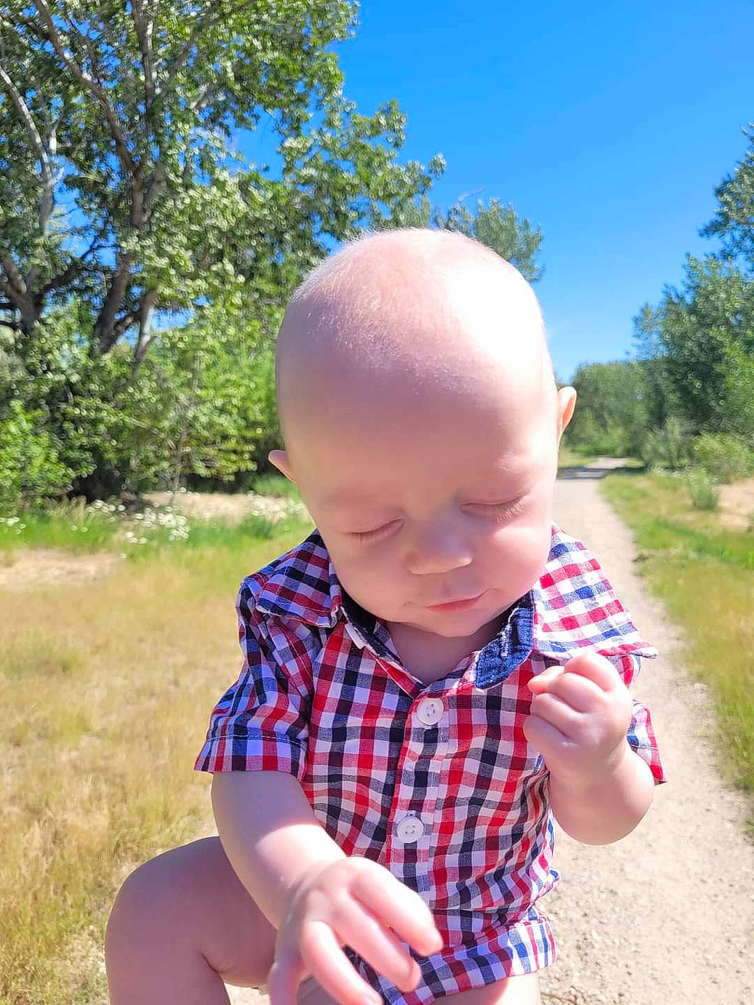 Hudson is registered to the contest to win money with this photo: arm, baby, baby_toddler_clothing, chin, eye, finger, gesture, grass, hand, happy, headwear, leisure, people_in_nature, person, plant, skin, sky, smile, summer, tartan