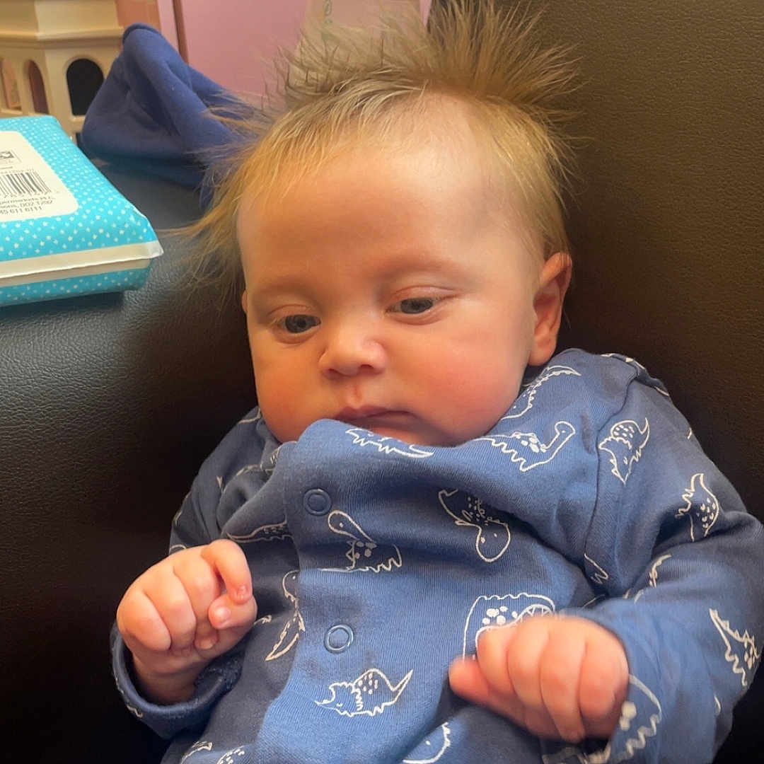 Apollo-James is registered to the contest to win money with this photo: baby, bed, blanket, bodypart, clothing, coat, couch, face, finger, furniture, hand, head, jacket, newborn, pajamas, pants, person, photography, portrait, quilt