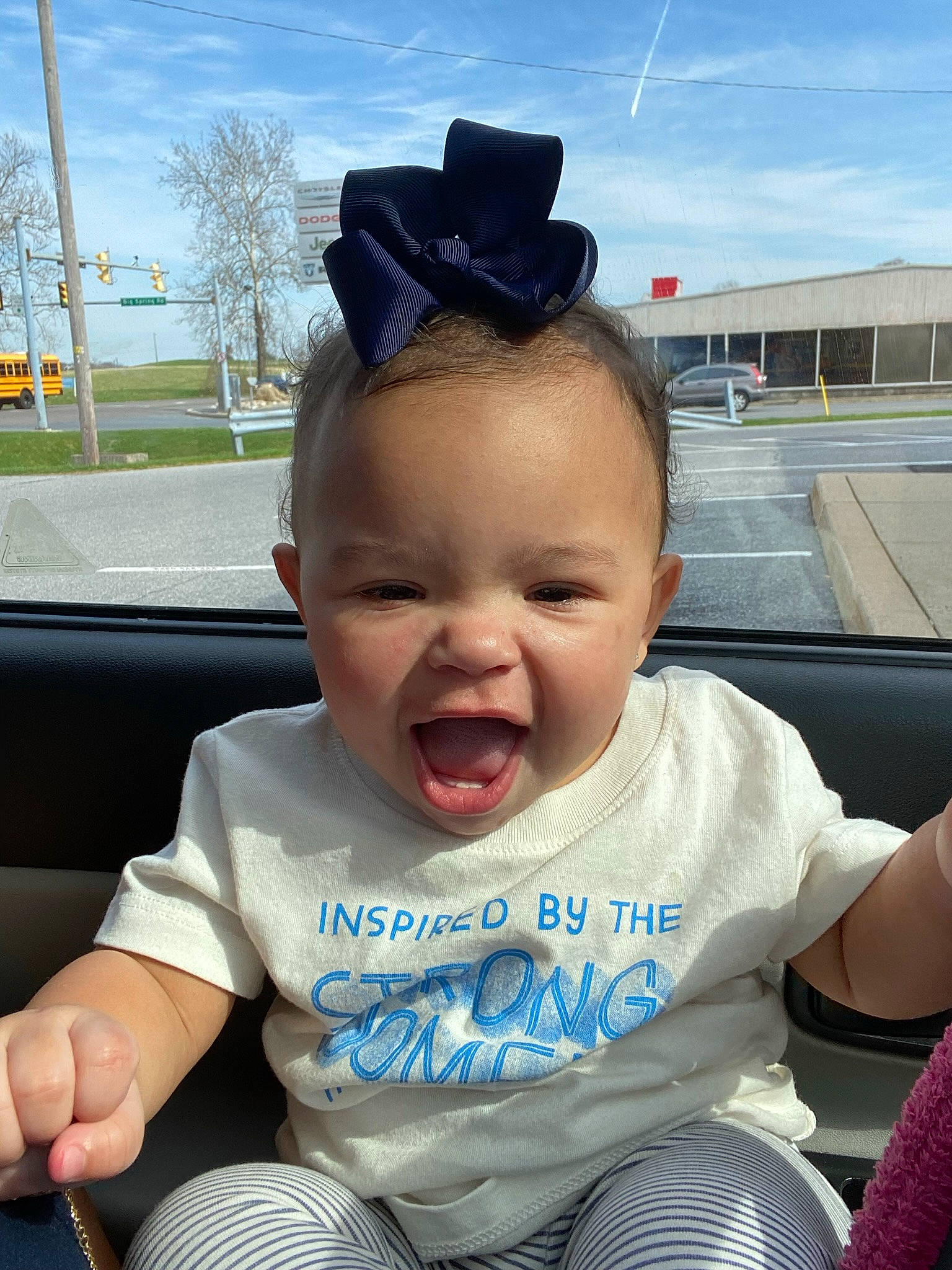 Isabella is registered to the contest to win money with this photo: auto_part, baby, baby_toddler_clothing, child, cloud, cool, fashion_accessory, finger, fun, grass, hairstyle, happy, person, sitting, skin, sky, smile, steering_wheel, t_shirt, toddler