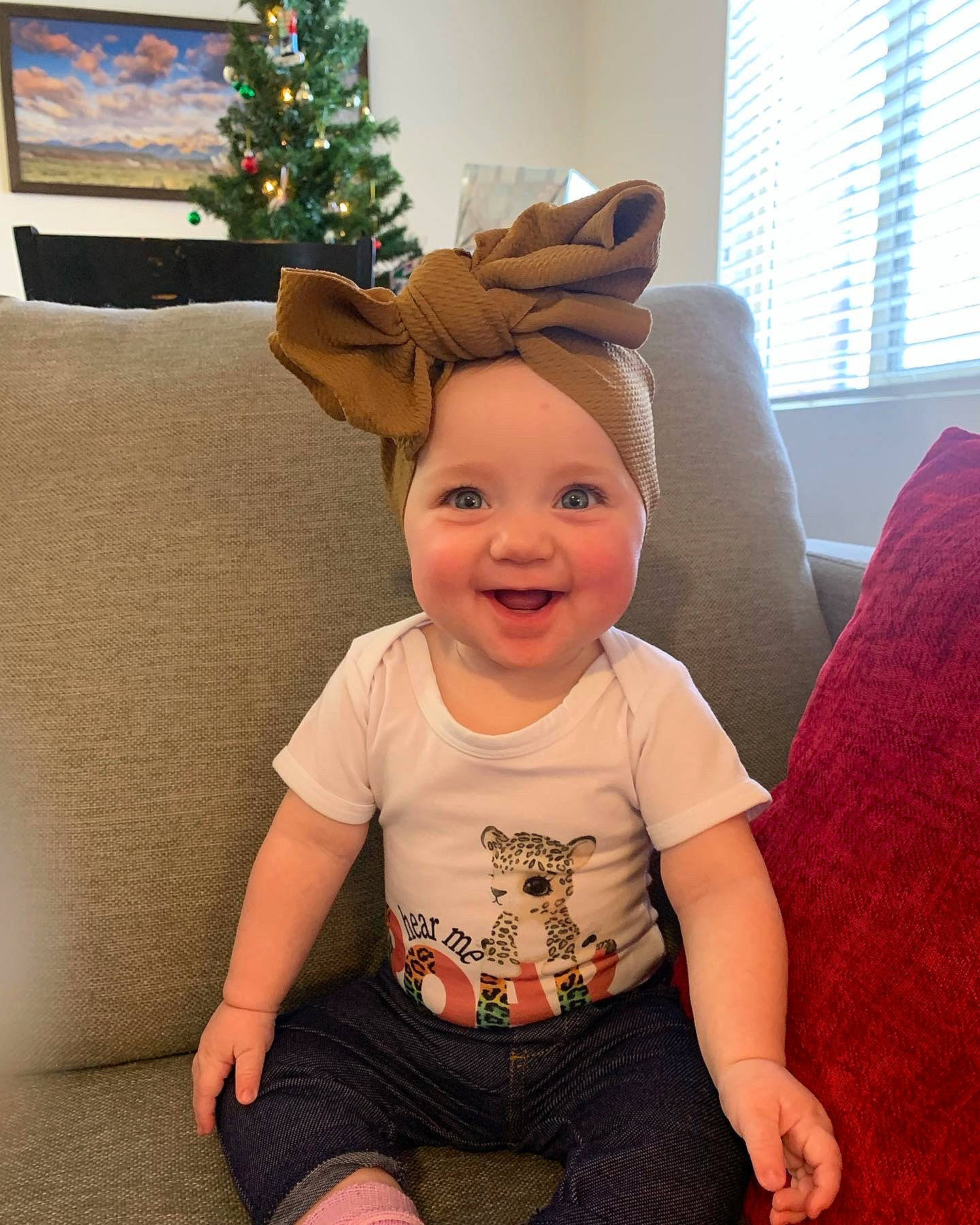 Kaycee joined the competition — help win amazing prizes! baby, baby_toddler_clothing, child, christmas_ornament, christmas_tree, costume_hat, couch, event, flooring, fun, happy, headwear, holiday, holiday_ornament, joy, person, sleeve, smile, standing, toddler