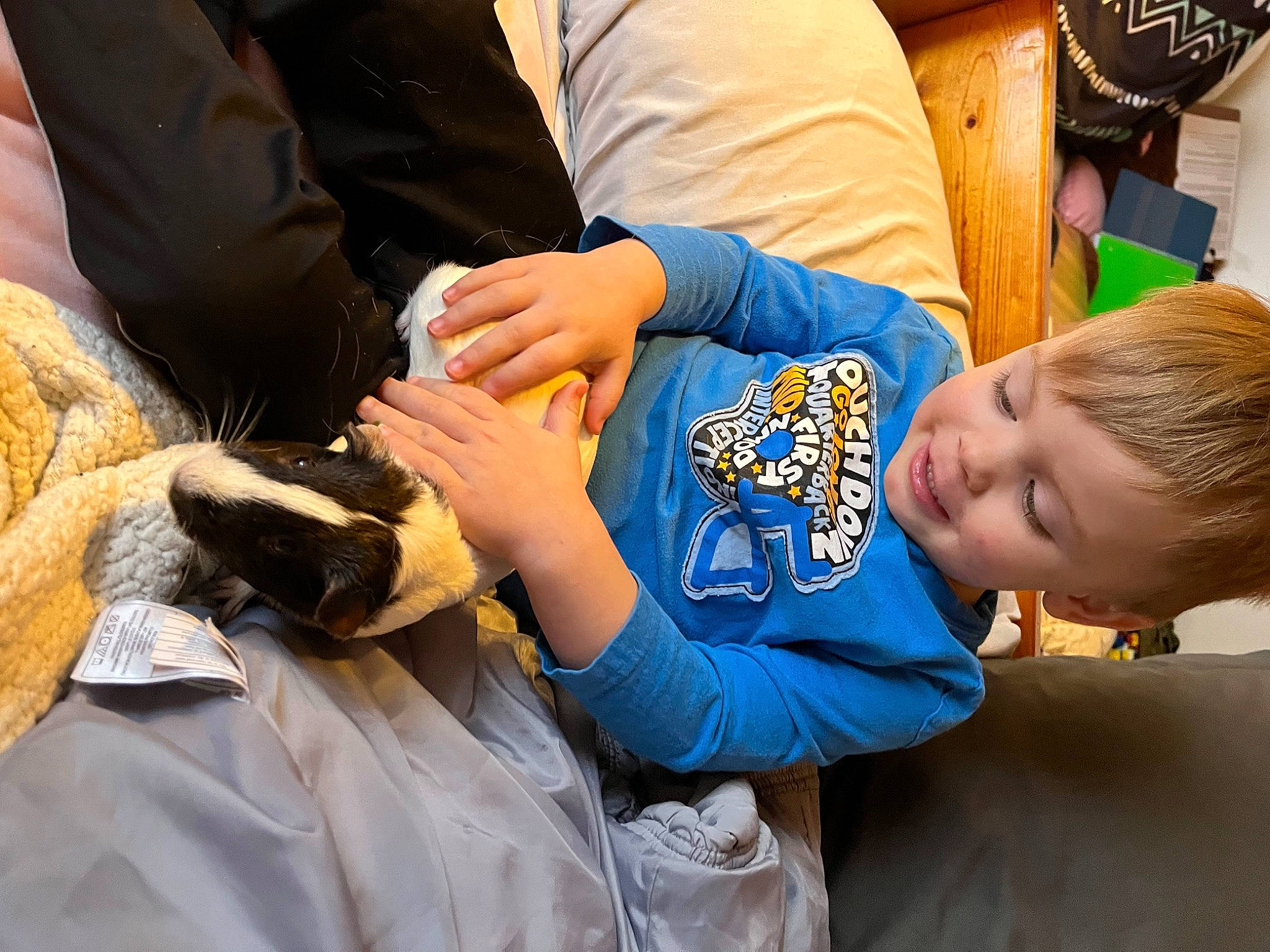Riley is registered to the contest to win money with this photo: arm, baseball_glove, child, college_baseball, comfort, elbow, feather, finger, gesture, glove, hand, interaction, joint, joy, mammal, person, safety_glove, sitting, smile, t_shirt