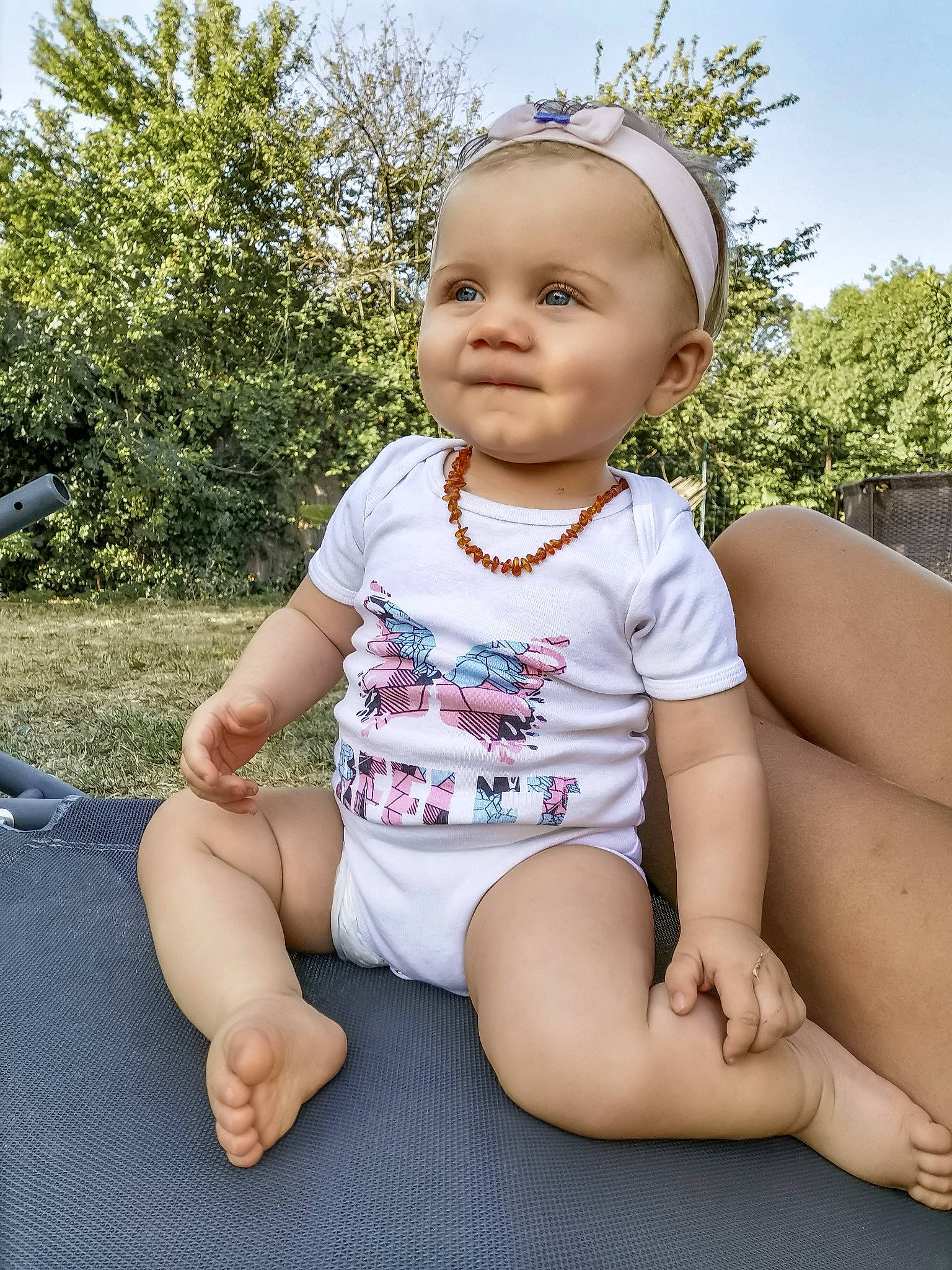 Lana participe au concours pour gagner de l'argent avec cette photo : baby, baby_toddler_clothing, barefoot, child, child_model, grass, headgear, joy, leg, person, pink, sitting, skin, smile, summer, thigh, toddler