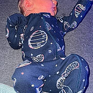 Christopher is registered to the contest to win money with this photo: newborn, baby, infant, sleeping, onesie, space_theme, planets, stars, blue_clothing, cozy, blanket, soft_surface, cute, peaceful, portrait, indoor, child, young, resting, human