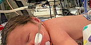 Weston is registered to the contest to win money with this photo: newborn, baby, hospital, medical_equipment, incubator, tubes, monitor, sleeping, patient, healthcare, premature, infant, blanket, medical_tape, nasal_cannula, clinic, care, fragile, bed, resting