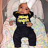 Lillyana is registered to the contest to win money with this photo: baby, black_outfit, blanket, bow_headband, child, close_up, crib, cushion, front_view, indoor, infant, lying_down, pastel_colors, penguins, pittsburgh, portrait, serious_expression, socks, sports_shirt, text_on_clothing