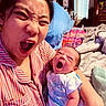 newborn, baby, infant, adult, mother, yawning, sleepy, portrait, closeup, bedroom, bed, blanket, pillow, onesie, clothing, holding, family, indoor, colorful, funny