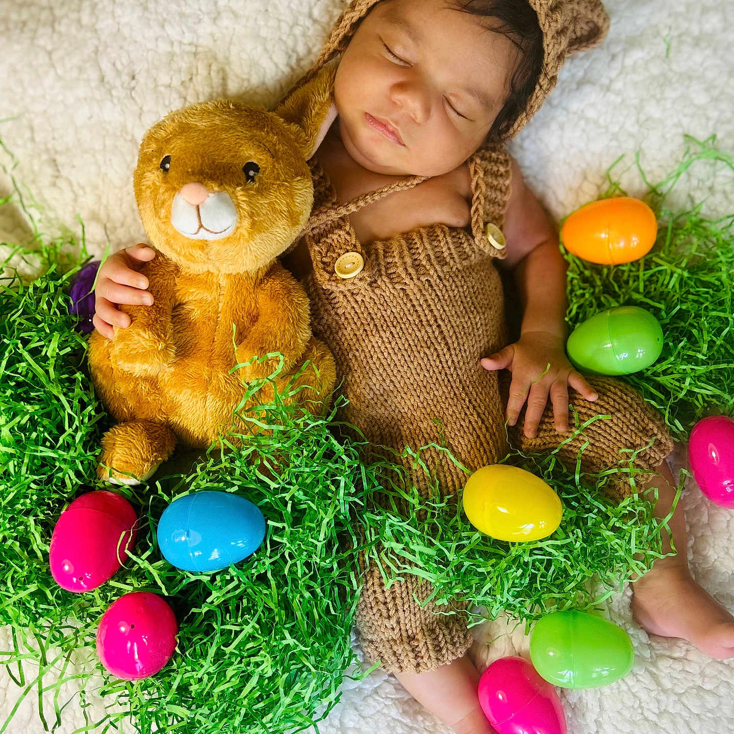 Elijah is registered to the contest to win money with this photo: accessories, baby, bodypart, bonnet, clothing, egg, face, food, grass, hat, head, jewelry, necklace, person, photography, plant, portrait, purple, teddybear, toy