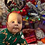 baby, child, reindeer_antlers, christmas_tree, christmas_pajamas, gingerbread_man, candy_cane, holiday, festive, pajamas, floor, wooden_floor, present, gift_wrap, decorations, indoor, holiday_season, cute, portrait, seasonal