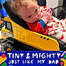 baby, child, toy_truck, tonka, onesie, crab_pattern, clothing, face, hands, indoor, furniture, portrait, cute, infant, expression, colorful, text_overlay, playful, soft_light, closeup