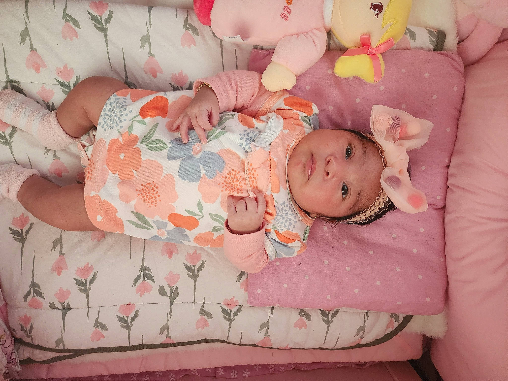 Arianna Aguilar is registered to the contest to win money with this photo: arm, baby, baby_products, baby_toddler_clothing, cheek, child, comfort, headwear, human_body, linens, orange, pattern, peach, person, pink, product, room, skin, teddy_bear, textile