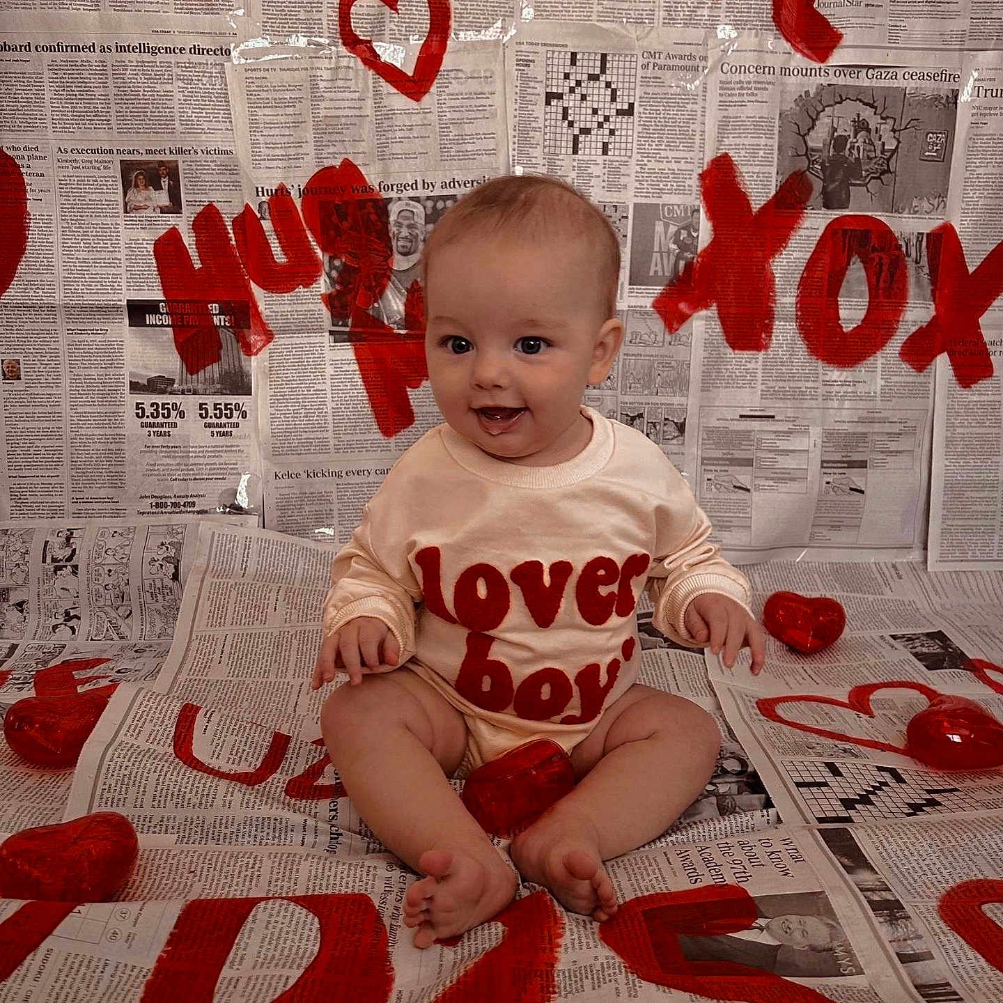 Waylon joined the competition — help win amazing prizes! accessories, baby, bodypart, clothing, face, finger, hand, head, jewelry, necklace, newspaper, number, pants, person, photography, portrait, sitting, symbol, t_shirt, text