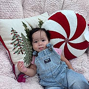 Liliana joined the competition — help win amazing prizes! baby, child, infant, overalls, striped_clothing, pink_shirt, fluffy_chair, pillows, christmas_pillow, peppermint_pillow, embroidered_pillow, indoor, cute, relaxed, portrait, person, soft_texture, holiday_theme, seated, young