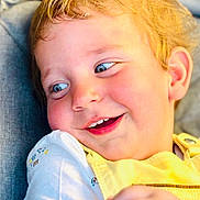 Tymaël participe au concours pour gagner de l'argent avec cette photo : baby, blonde_hair, blue_eyes, casual_clothing, child, closeup, cute, expression, face, happy, indoors, joyful, person, portrait, seated, smiling, soft_lighting, toddler, white_shirt, yellow_bib