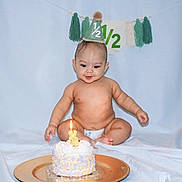 Kai joined the competition — help win amazing prizes! baby, cake, candle, party_hat, celebration, diaper, smile, tassel, background, plate, light_blue, sitting, happy, cute, infant, birthday, half_birthday, food, cream, decor