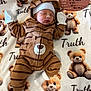 baby, newborn, sleeping, blanket, teddy_bear, milestone_board, mittens, hat, onesie, soft_texture, cute, portrait, indoor, lying_down, socks, striped, brown, white, peaceful, cozy