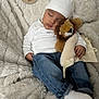 baby, infant, sleeping, plush_toy, lion_stuffed_animal, blanket, white_hat, white_shirt, jeans, socks, milestone_sign, two_months, cozy, soft_texture, nursery, portrait, newborn, asleep, peaceful, cuddling