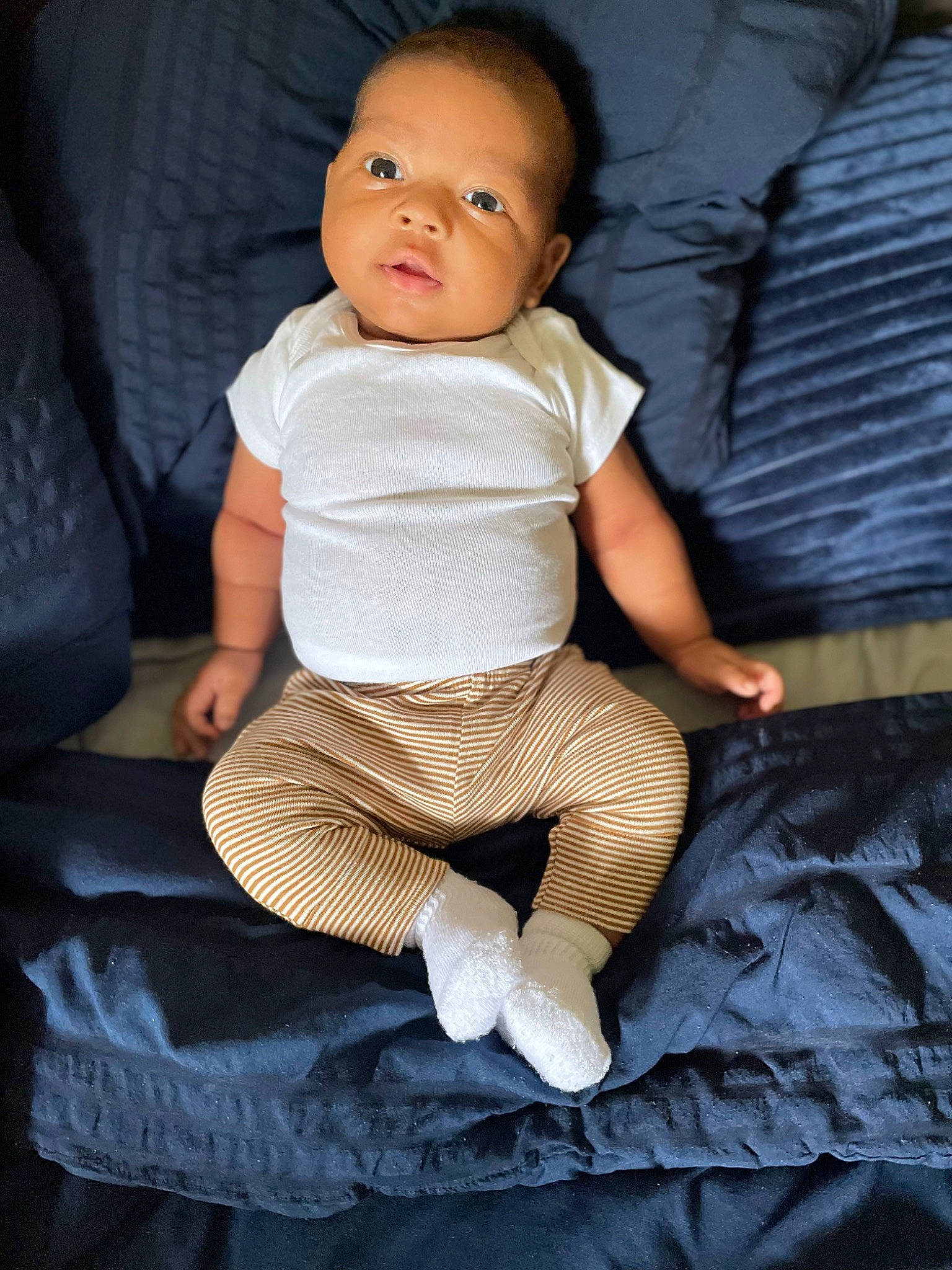 Jamir joined the competition — help win amazing prizes! baby, baby_toddler_clothing, cheek, child, comfort, couch, eye, fashion_accessory, flash_photography, happy, human_leg, knee, linens, person, sitting, skin, sleeve, sock, t_shirt, thigh