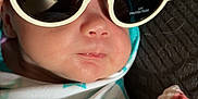Lillian joined the competition — help win amazing prizes! baby, sunglasses, blanket, star_pattern, face, person, infant, wrapped, head, expressionless, indoor, clothing, quilt, fabric, closeup, skin, hand, nose, mouth, eyewear