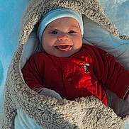 Nahïl participe au concours pour gagner de l'argent avec cette photo : baby, child, smiling, tongue_out, winter, snow, blanket, cozy, red_clothing, hat, cute, cold_weather, fur, happy, face, infant, outdoor, warm_clothing, person, playful