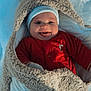 baby, child, smiling, tongue_out, winter, snow, blanket, cozy, red_clothing, hat, cute, cold_weather, fur, happy, face, infant, outdoor, warm_clothing, person, playful