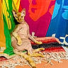 Socka is registered to the contest to win money with this photo: cat, sphynx_cat, hairless_cat, animal, pet, indoor, colorful, blanket, fringe, pattern, artistic_background, orange, green, yellow, blue, red, relaxed, posing, feline, portrait