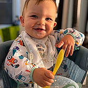 Maélïo a rejoint le concours — aidez-le/la à gagner de superbes lots ! baby, child, smiling, spoon, bowl, cereal, bib, feeding, highchair, indoor, happy, cute, messy, food, person, table, clothing, face, portrait, toddler