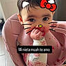 baby, infant, child, high_chair, sitting, portrait, face, eyes, dark_hair, smiling, hand, food, food_splatter, pink, bib, floral_clothing, kitchen, indoors, hello_kitty_filter, text_overlay