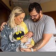 Kayleigh joined the competition — help win amazing prizes! baby, newborn, adult, woman, man, batman_hoodie, tattoo, glasses, indoor, family, love, parent, child, holding, smiling, casual_clothing, portrait, tenderness, affection, people