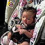 baby, infant, pacifier, car_seat, floral_pattern, bracelet, pink_socks, child, newborn, seatbelt, cute, portrait, indoors, soft_toys, baby_accessory, hand, face, head, person, sitting