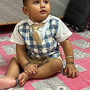 Areeb joined the competition — help win amazing prizes! toddler, child, indoor, bedspread, pink, vest, tie, shorts, bracelet, pillow, sitting, curious, hands, feet, floor, fabric, pattern, portrait, cute, young
